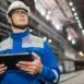 Decorative image for blog post on the importance of cybersecurity for manufacturers and warehouses in Chicagoland. Image depicts man with an ipad in a large warehouse in work clothes.